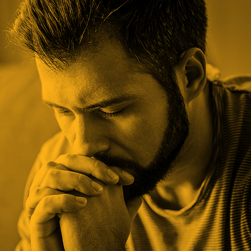 A man with a beard looks worried. The image is tinted yellow.