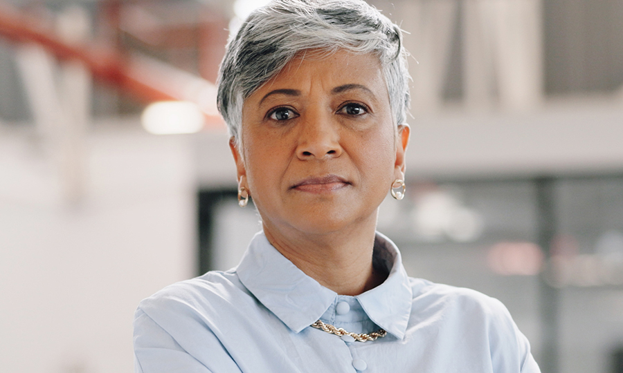 A professional individual with short grey hair and a serious expression.